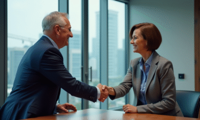 Deux professionnels se serrent la main dans une salle de réunion moderne